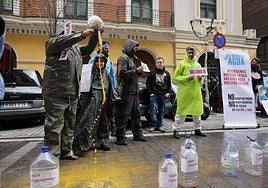 Un manifestante vuelca una garrafa de agua contaminada durante la concentración celebrada en Valladolid.
