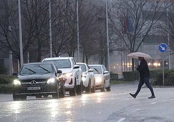 Un peatón atraviesa la calle en pleno chaparrón.