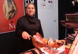 Ángela Petrean corta un jamón en su charcutería de San Rafael.