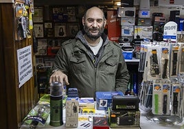Jorge de Prado, tras el mostrador de Radio Valdeprado, con productos del kit de supervivencia.