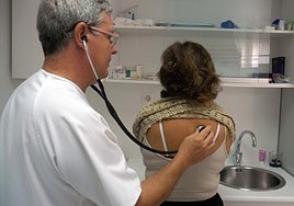 Un médico ausculta a una paciente en la consulta.