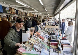 El público curiosea entre las estanterías en el interior y frente al expositor de una caseta.