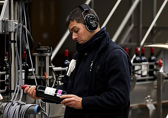 Un trabajador de Protos examina la etiqueta de una botella de vino con destino a Estados Unidos en la sede de la bodega vallisoletana en Peñafiel.