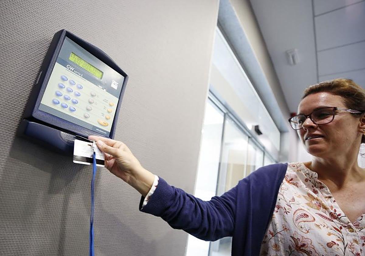 Una trabajadora ficha al término de su jornada laboral.