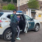 Un guardia civil introduce en el vehículo patrulla a uno de los detenidos.