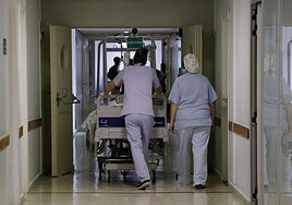 Dos profesionales trasladan a un enfermo a quirófano en el Hospital Río Carrión.