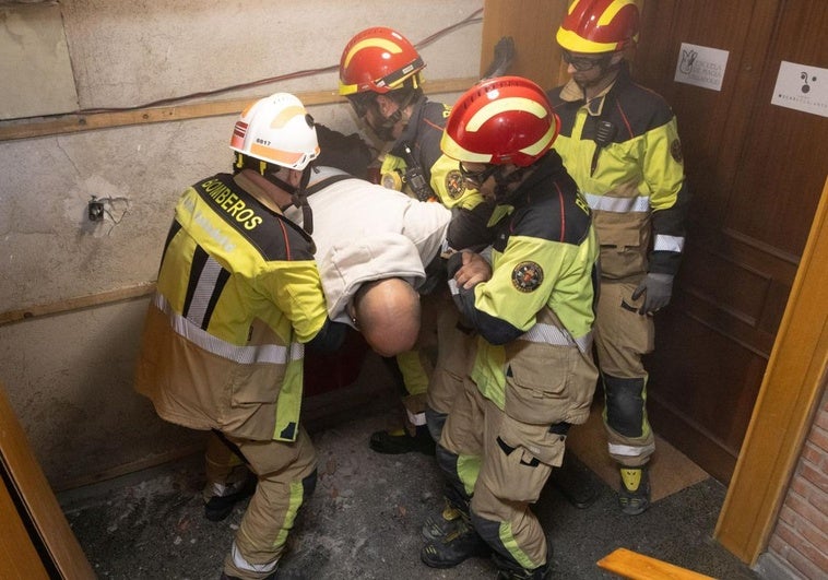 Los bomberos sacan a Amador del ascensor después de cinco horas.