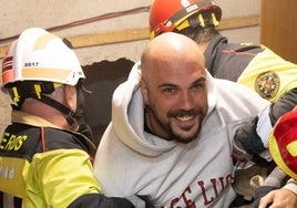 Amador Matallana, en el centro, con el butrón por el que salió, a su espalda.