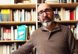 Alberto Gómez Vaquero junto a su biblioteca.