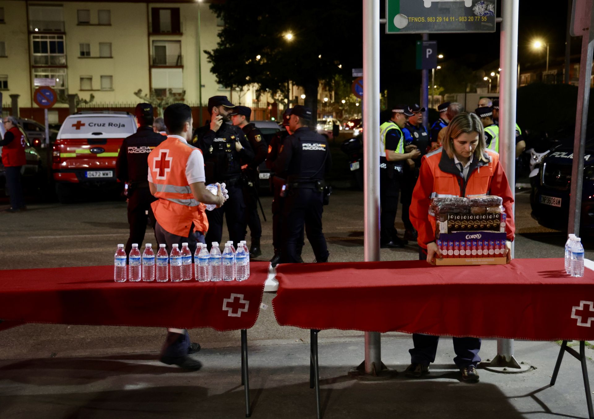Efectivos de Cruz roja preparan las mesas con bebida y alimentos para los viajeros que se disponían a pasar la noche en la estación de tren de Valladolid.