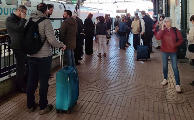 Pasajeros aguardan la llegada de un tren con destino Madrid, minutos antes de las ocho de la mañana de este martes.