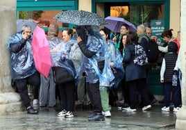 Un grupo de personas intenta refugiarse de la lluvia este viernes en Segovia capital.