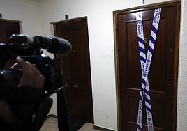 La puerta de la vivienda de Ávila donde fueron halladas muertas dos personas, precintada por la Policía.