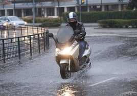 Un motorista circula por Valladolid un día lluvioso.