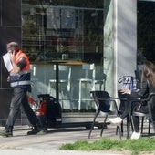 Un trabajador de una empresa de mantenimiento pasa delante de una terraza en Valladolid.