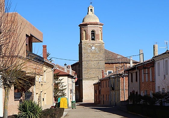 Una de las calles de la localidad en la que se aprecia la iglesia al fondo.