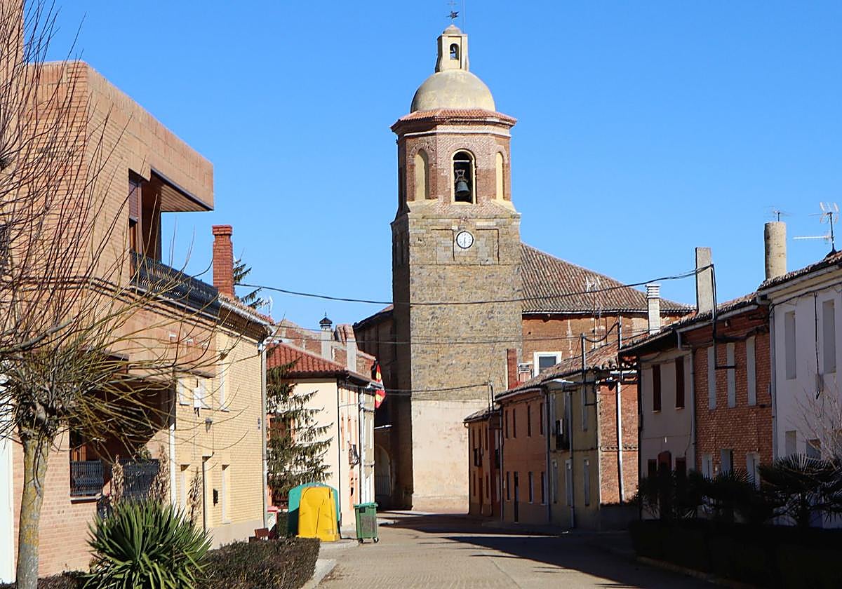 Una de las calles de la localidad en la que se aprecia la iglesia al fondo.