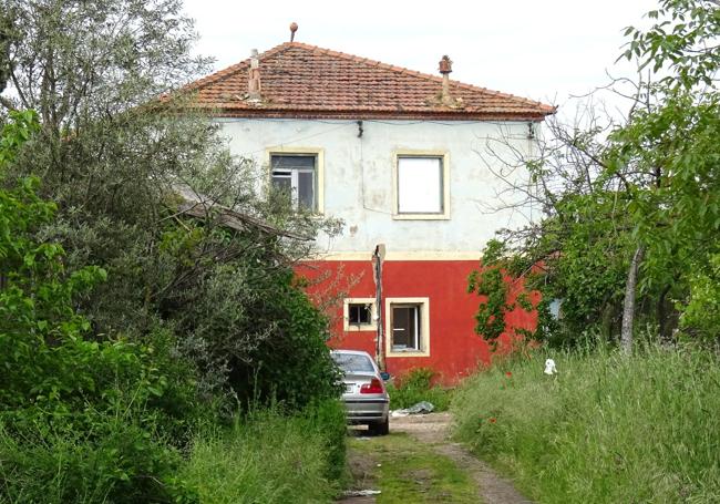 La casa ocupada ilegalmente en el interior de la propiedad municipal, con un coche aparcado delante.