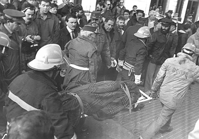 Bomberos y trabajadores de Renfe trasladan uno de los cadáveres.