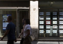 Anuncios de pisos en venta en el escaparate de una inmobiliaria en Valladolid.