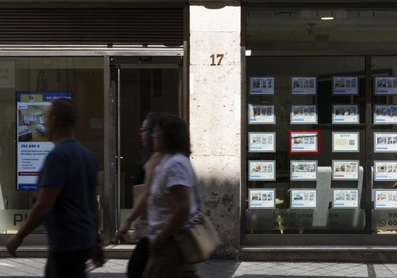 Anuncios de pisos en venta en el escaparate de una inmobiliaria en Valladolid.