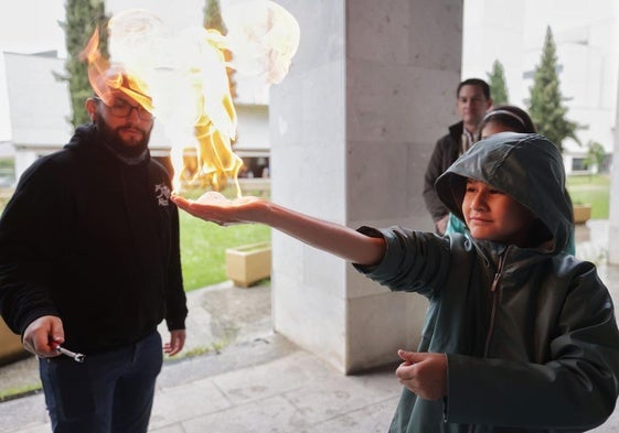 Un niño experimentando en la feria con fuego en la mano