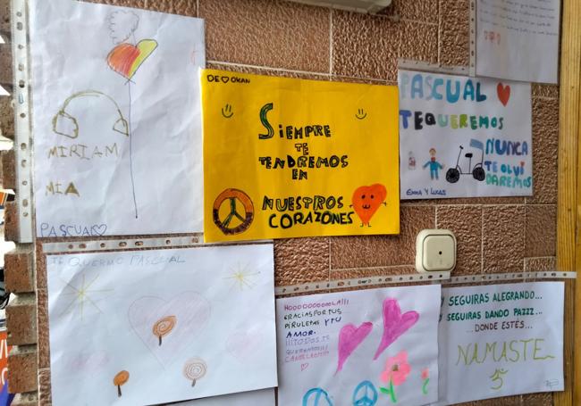 Carteles que varios niños del municipio han pegado en la puerta de la casa de Pascual en su recuerdo.