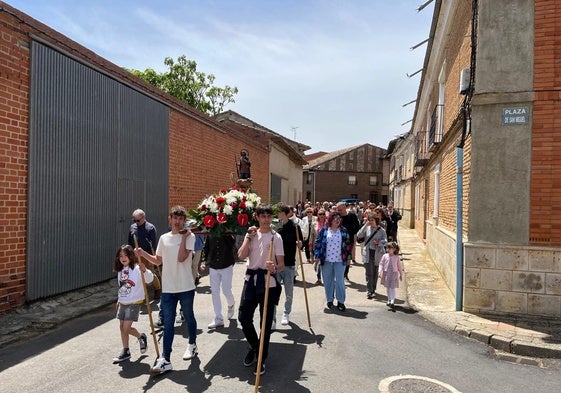 Varios jóvenes portan el paso de San Isidrín por las calles de la localidad