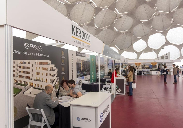 Clientes potenciales informándose en el expositor de Ker 2000