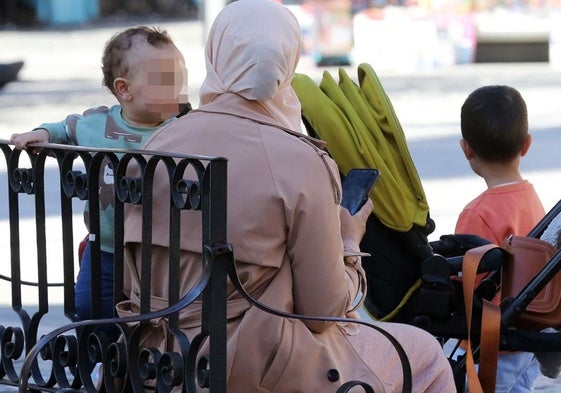 Una mujer musulmana cuida de sus hijos en una céntrica calle de Segovia.