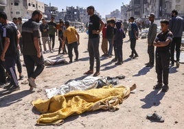 Palestinos junto a los cuerpos de las personas que murieron durante un ataque con aviones no tripulados israelíes en Jabalia, al norte de Gaza.
