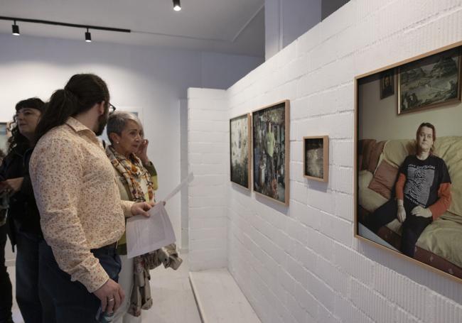 Varias personas, frente al retrato de Irma, que forma parte de la exposición.