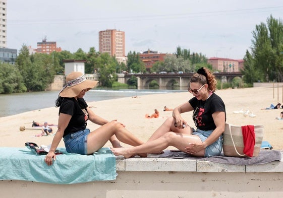 Dos mujeres toman el sol este lunes al mediodía en la playa de Las Moreras.