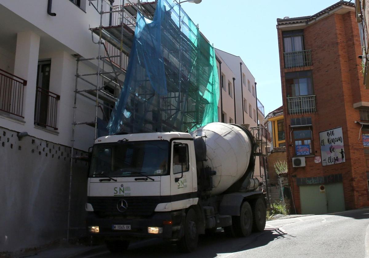 Maquinaria junto a los andamios que cubren un bloque de pisos de reciente construcción.