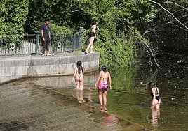 Un grupo de jóvenes se refresca en el Eresma a la altura de la Casa de la Moneda.