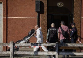 Los servicios funerarios trasladan de la vivienda uno de los cuerpos.