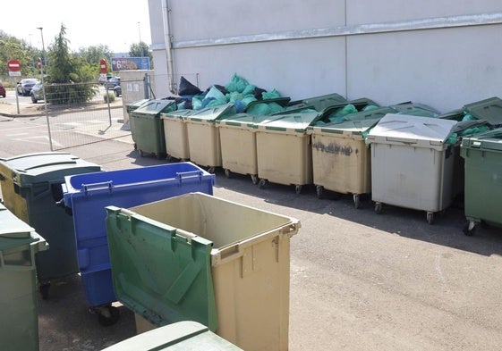 Contenedores de basura totalmente llenos con bolsas de residuos, en el exterior del Hospital.
