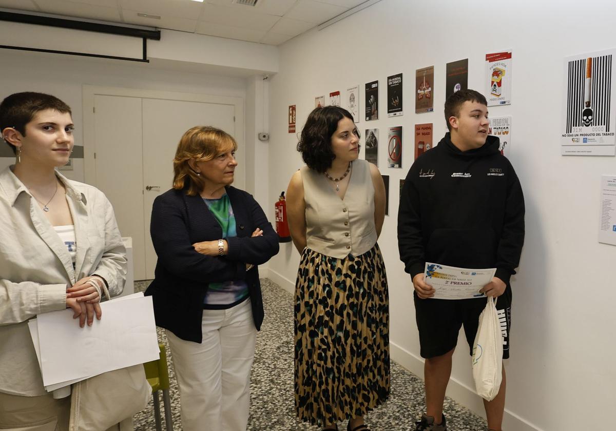 La presidenta de la Asociación del Cáncer de Palencia y la diputada de Juventud observan los carteles ganadores del concurso junto con sus diseñadores, Mireya Fernández y Jorge Aristín, este viernes.