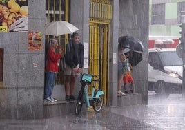 Los vallisoletanos se resguardan de la lluvia en la tormenta del pasado viernes.