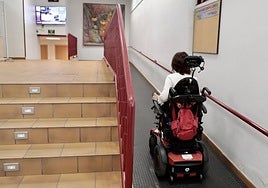 Una mujer con discapacidad sube una rampa en un centro cívico de Valladolid.