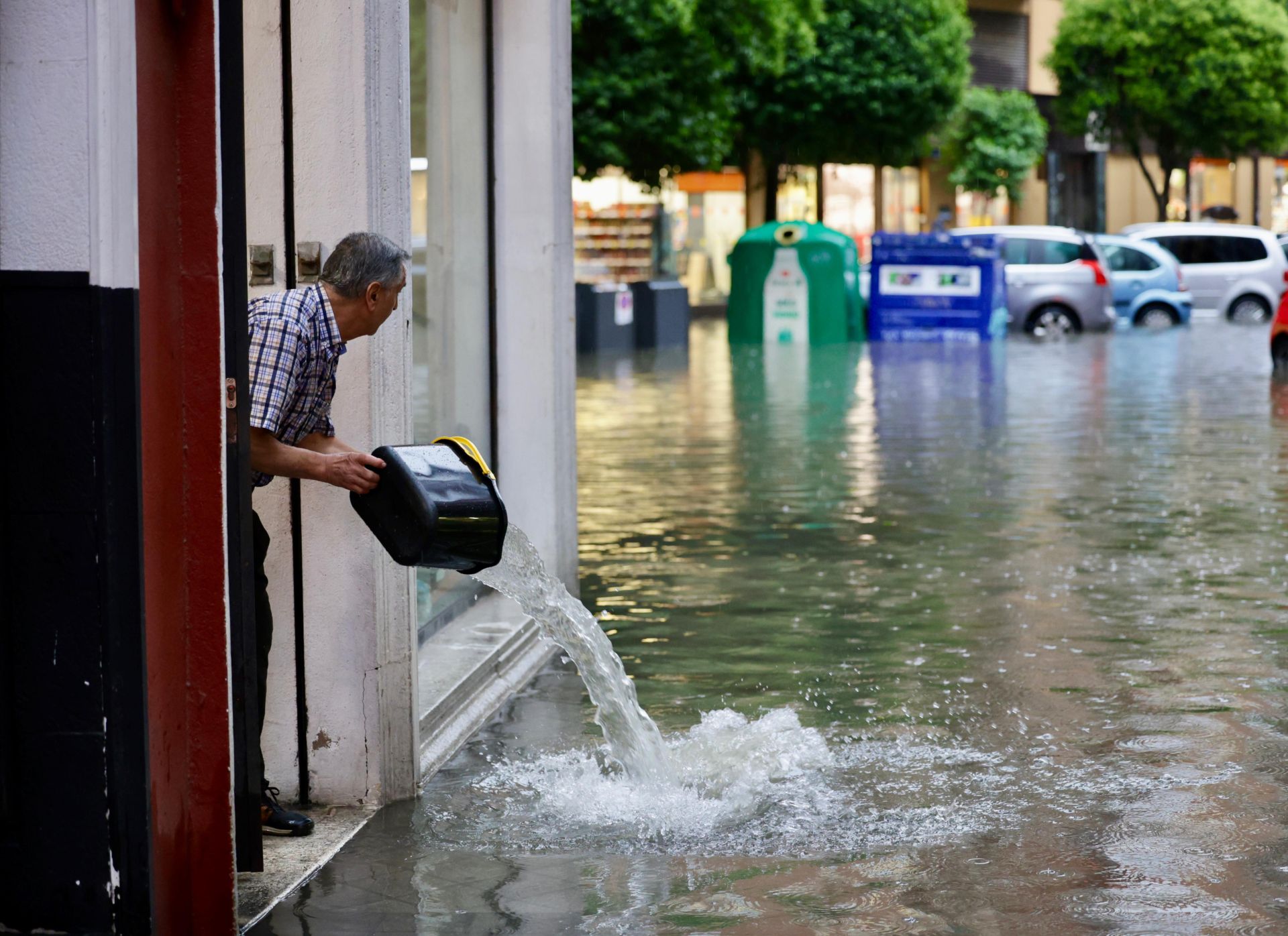Achique de agua a cubos en uno de los comercios de la calle Esgueva.
