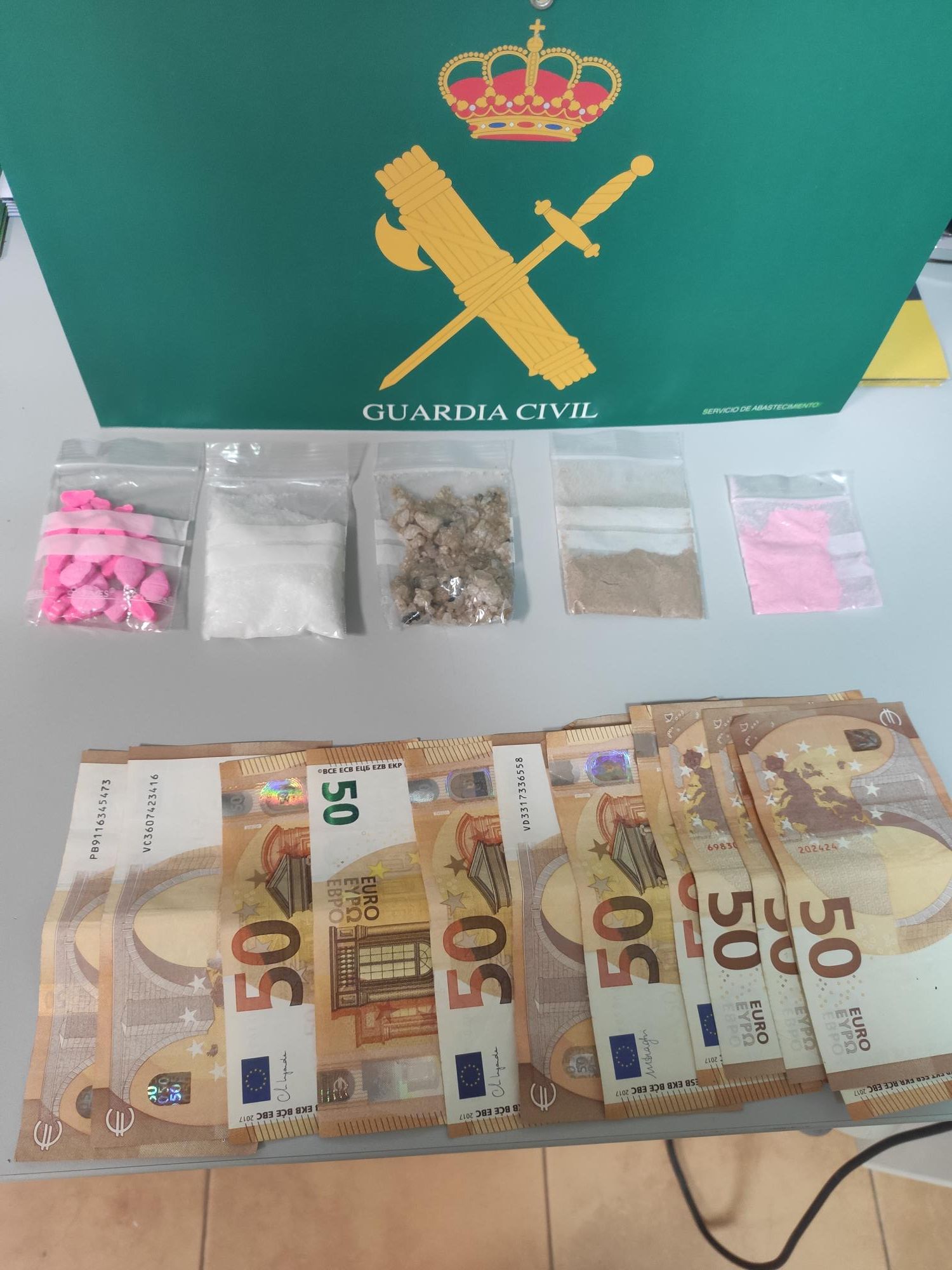 Dinero y drogas encontradas en el vehículo del detenido.