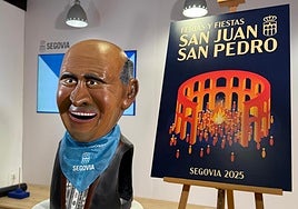El nuevo cabezudo, con el pañuelo de las fiestas y junto al cartel de este año.