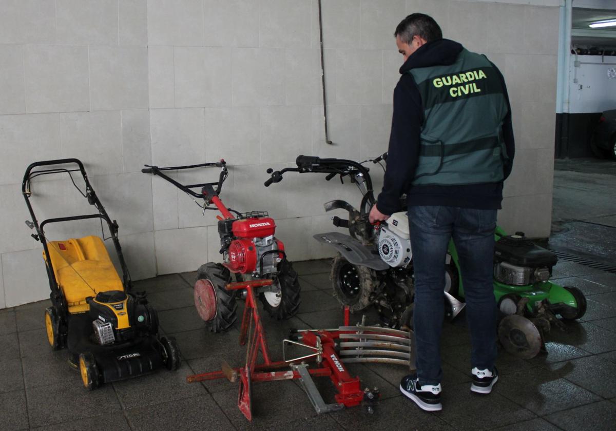 Un agente de la Guardia Civil junto a parte de la maquinaría que había sido robada.