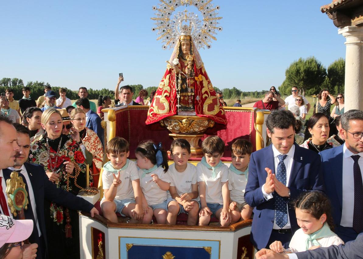 Imagen secundaria 1 - Arriba, multitud de fieles y curiosos aplauden la salida de la ermita de la Virgen del Bustar; abajo, niños montados en la carroza con la imagen de la patrona de Carbonero el Mayor, y a la derecha, jóvenes con los tamboriles preparados para hacerlos sonar al paso de la talla.