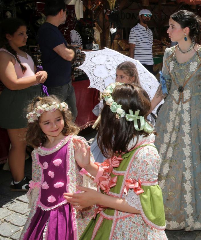 Imagen secundaria 2 - Arriba, desfile de vestidos de época en el Mercado Barroco, abajo una exhibición de cetrería y a la derecha, unas niñas disfrazdas pasean por los puestos de artesanía. 