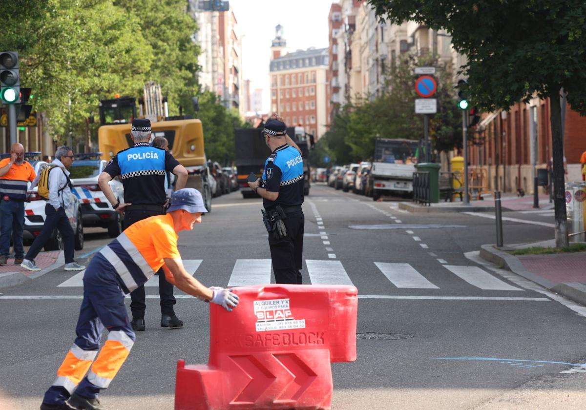 Un operario mueve una pieza de un vallado de plástico en la entrada a Gamazo en presencia de los agentes de la Policía Local.
