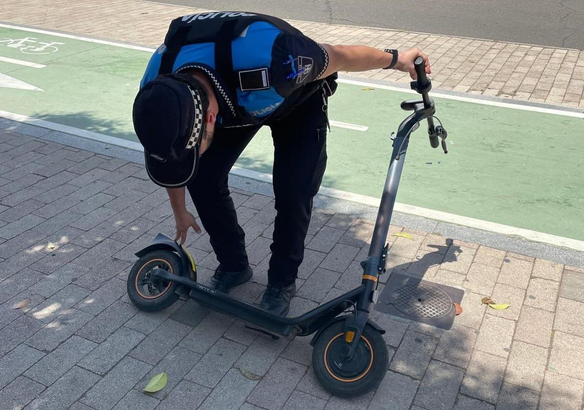 Un agente inspecciona un patinete eléctrico.
