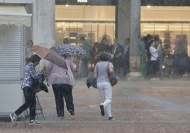 Tres mujeres corren para protegerse de la fuerte tormenta del 3 de junio en Valladolid.