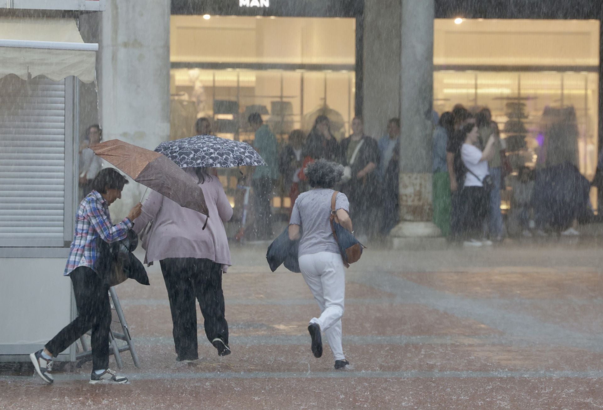 Tres mujeres corren para protegerse de la fuerte tormenta del 3 de junio en Valladolid.